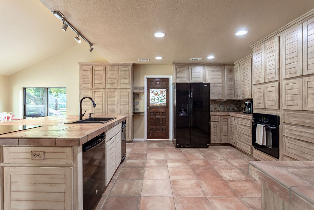 Spacious kitchen with large island and view of the pool in this 5-bedroom, 4-bathroom vacation rental house for 16+ guests with pool, free wifi, guesthouse and game room just 20 minutes away from downtown Waco, TX.