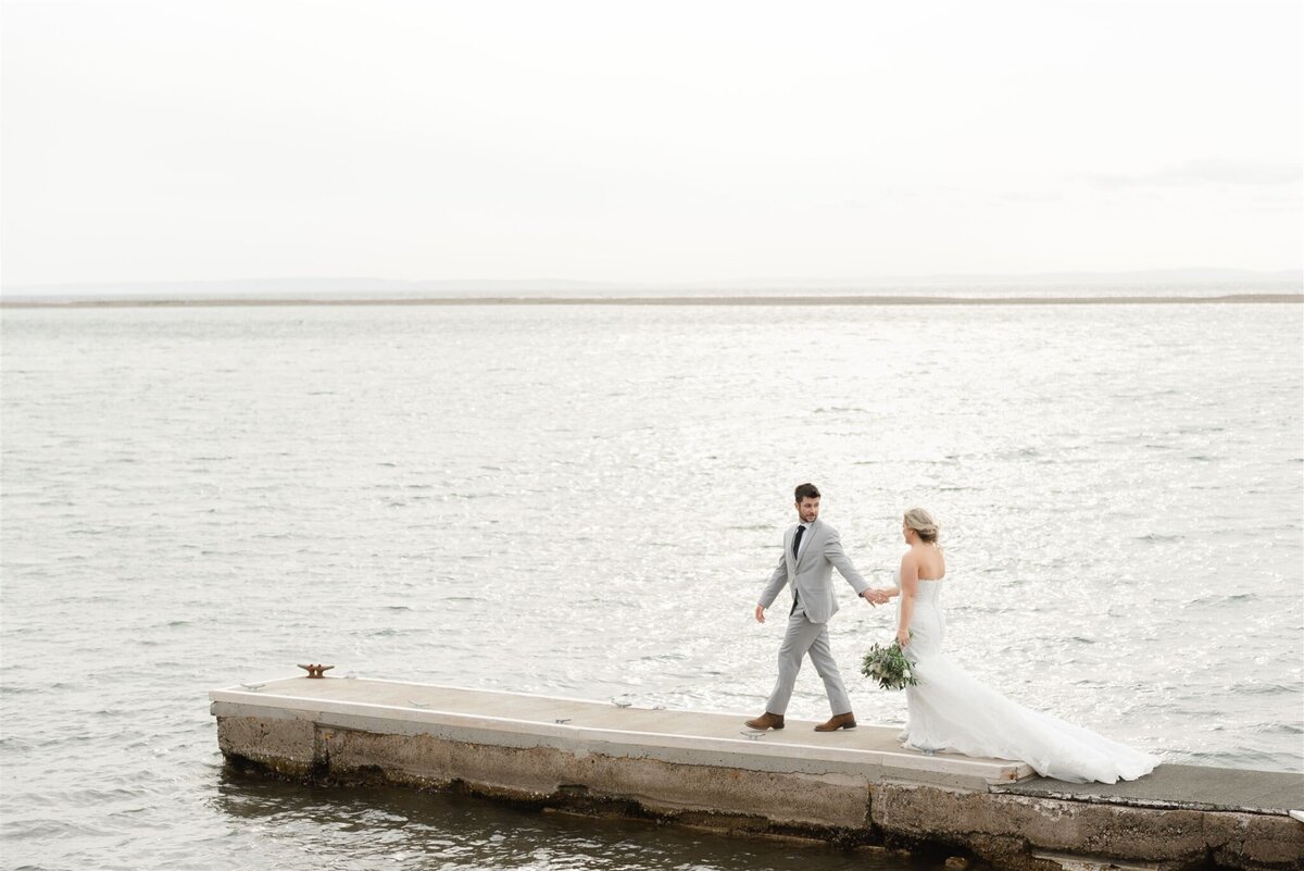 Bride and Groom walking along a warf on the barasd'or lakes  on Cape Breton Island, in Nova Scotia, Canada