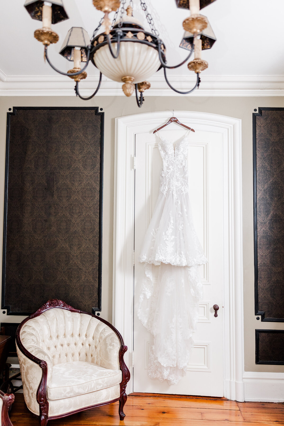 wedding dress hanging on a door at a wedding venue