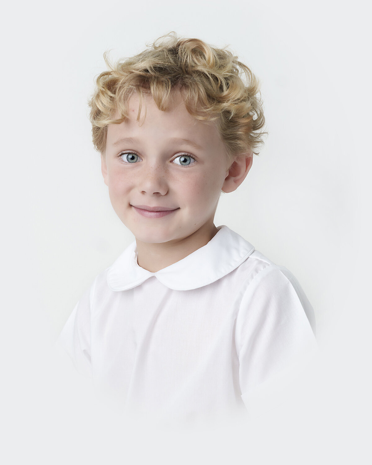 6 year old boy photographed in the southern heirloom bust portrait style with a peter pan collar shirt from The Bailey Boys