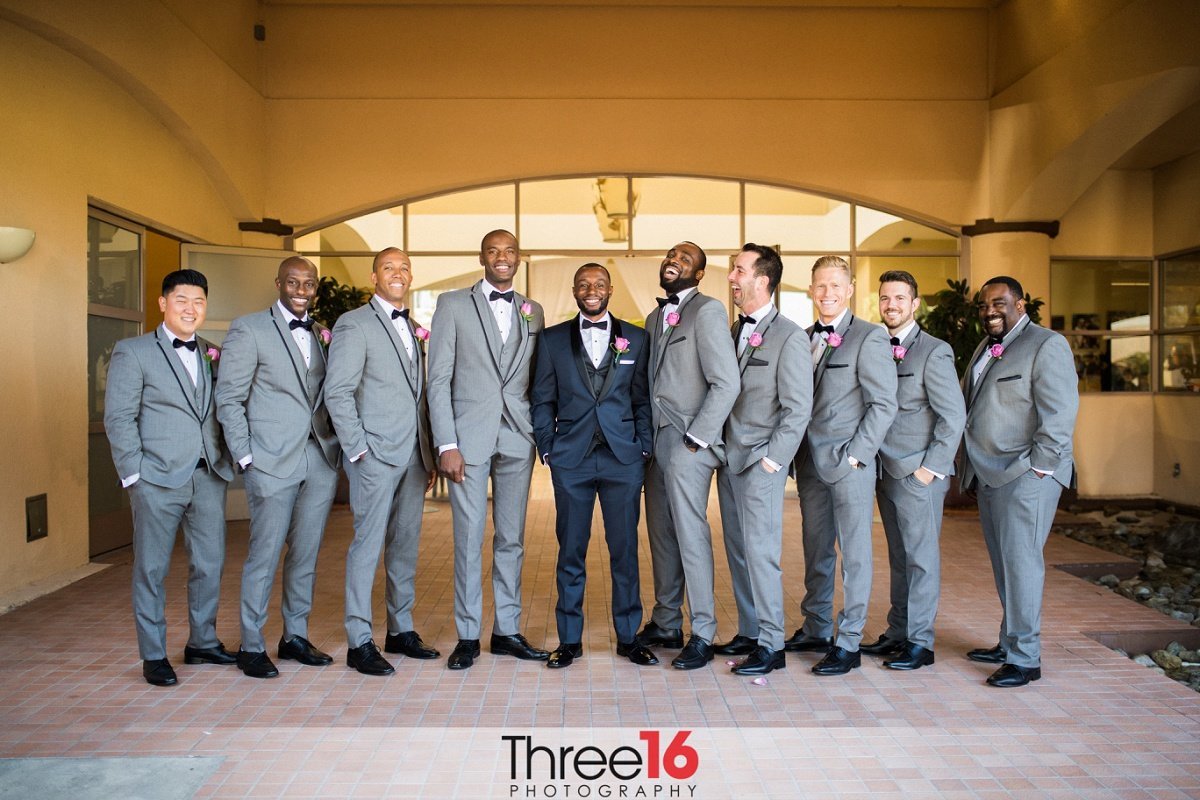 Groom and Groomsmen share a laugh as they pose together