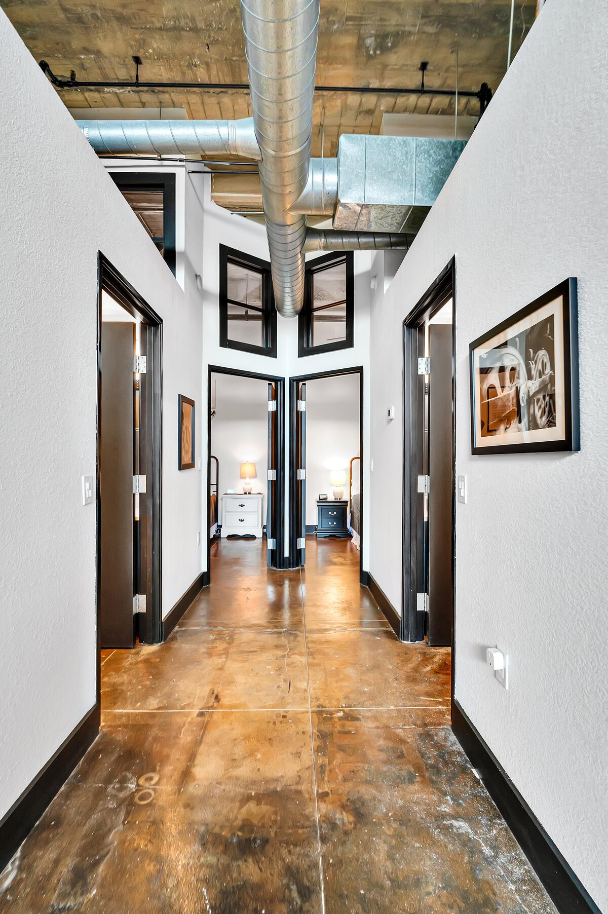 Hallway with view of the bedrooms at this two-bedroom, two-bathroom vacation rental condo in the historic Behrens building in the heart of the Magnolia Silo District in downtown Waco, TX.