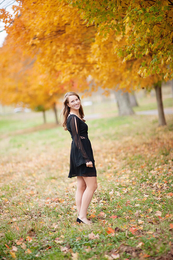 Senior session of young woman surrounded by trees