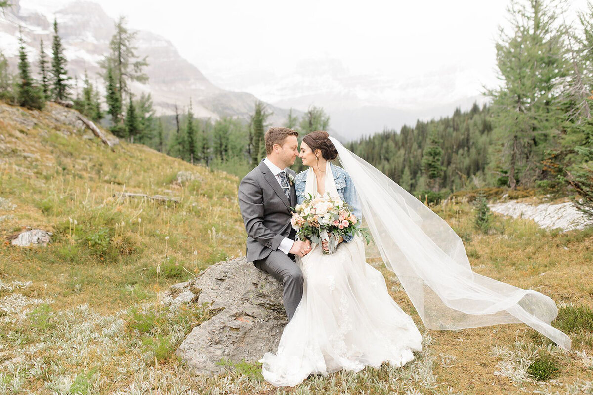 Couple sitting together in the mountains captured by Jennifer Chabot Photography, classic and romantic wedding photographer in Calgary,  Alberta. Featured on the Bronte Bride Vendor Guide.