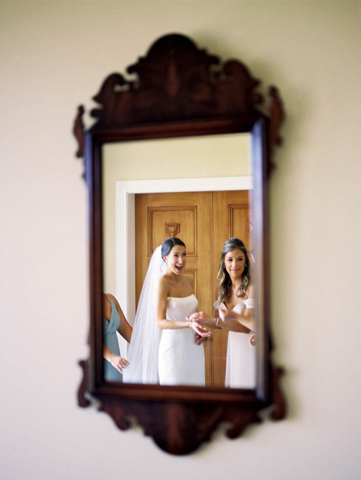 A bride with joy through a mirror  at bridal suite