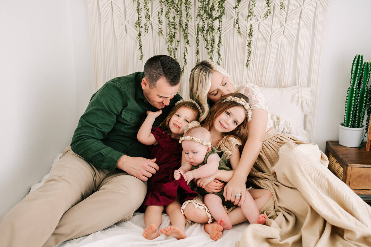 family cuddling in bed during Springfield MO family photography studio