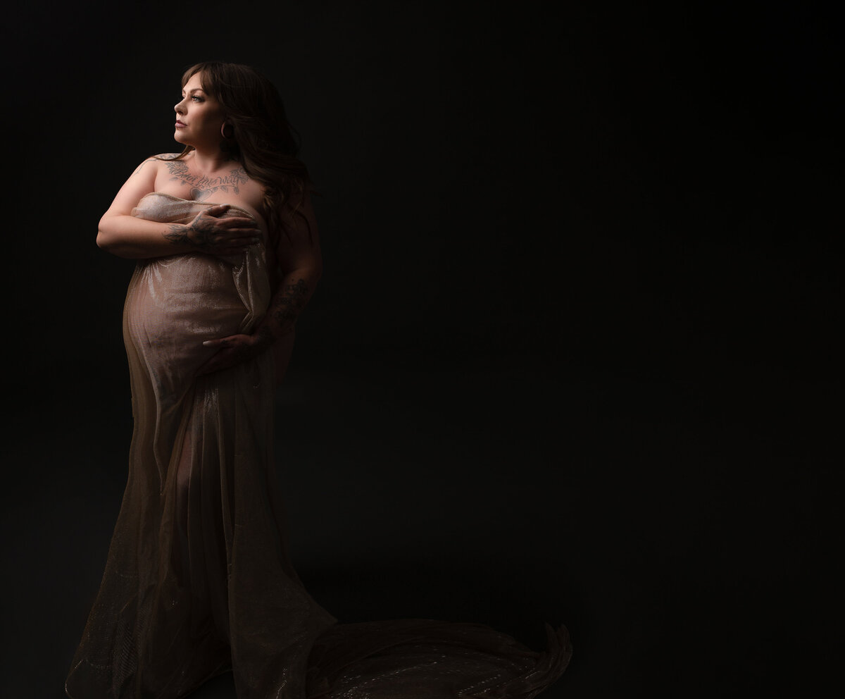 shadow image of pregnant mom in gold wrap