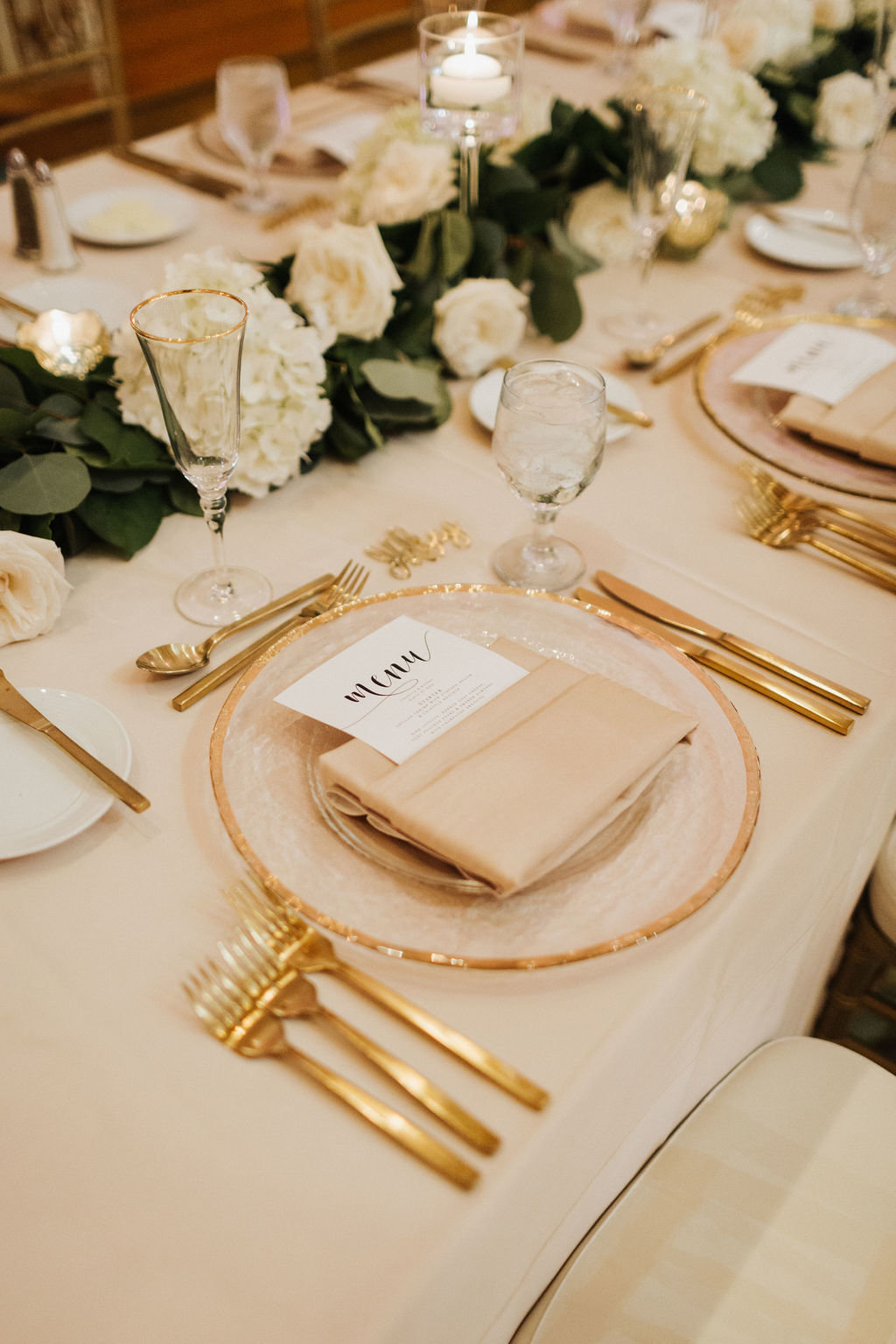 romantic tablescape with gold silverware and gold rim charger