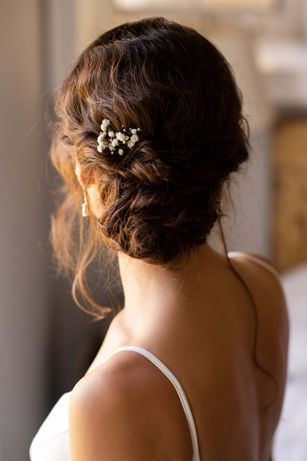 the back of a loose bridal hair updo adorned with baby's breath popular nowadays with Ottawa weddings