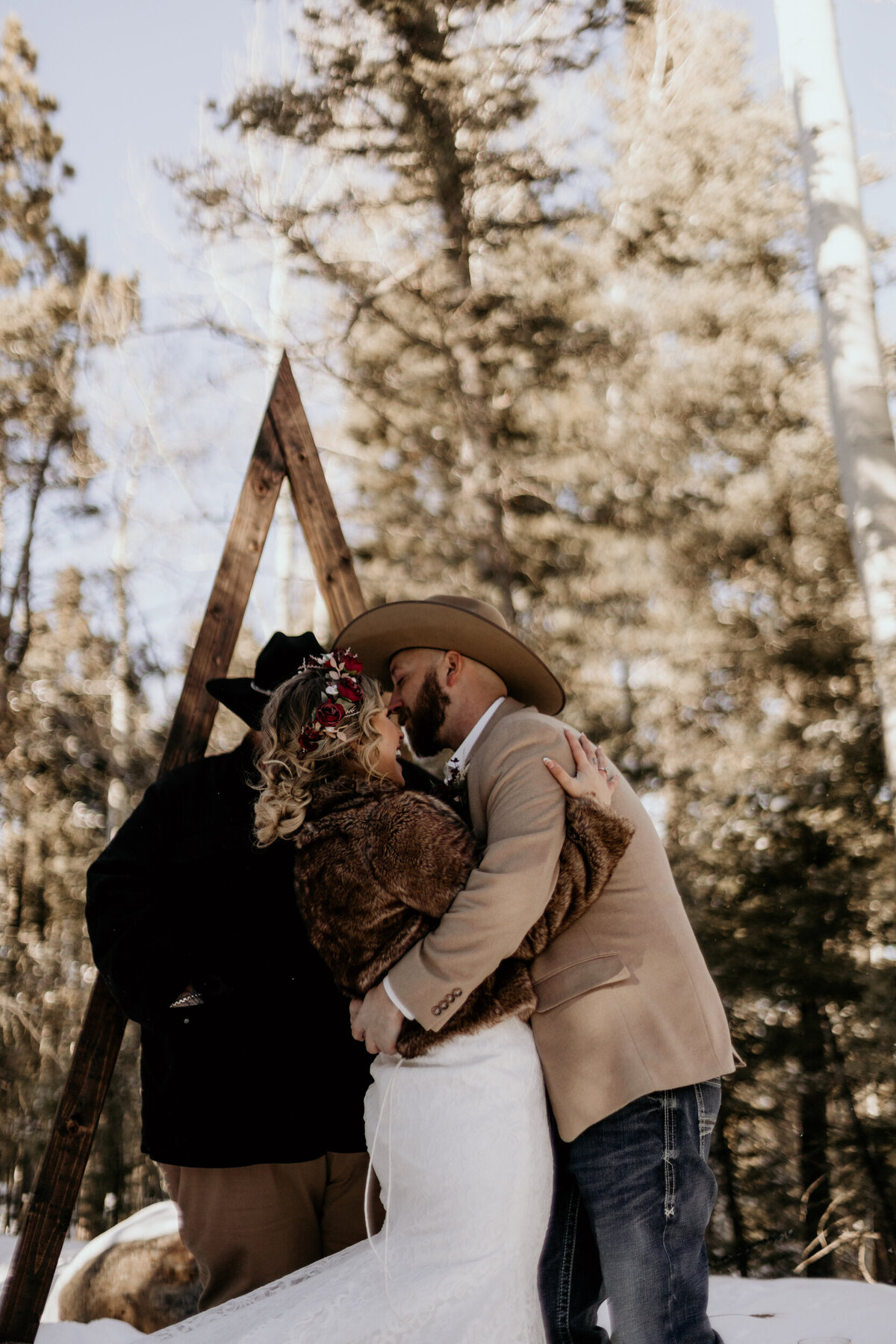 bride and grooms first kiss in the snow in Angel Fire New Mexico