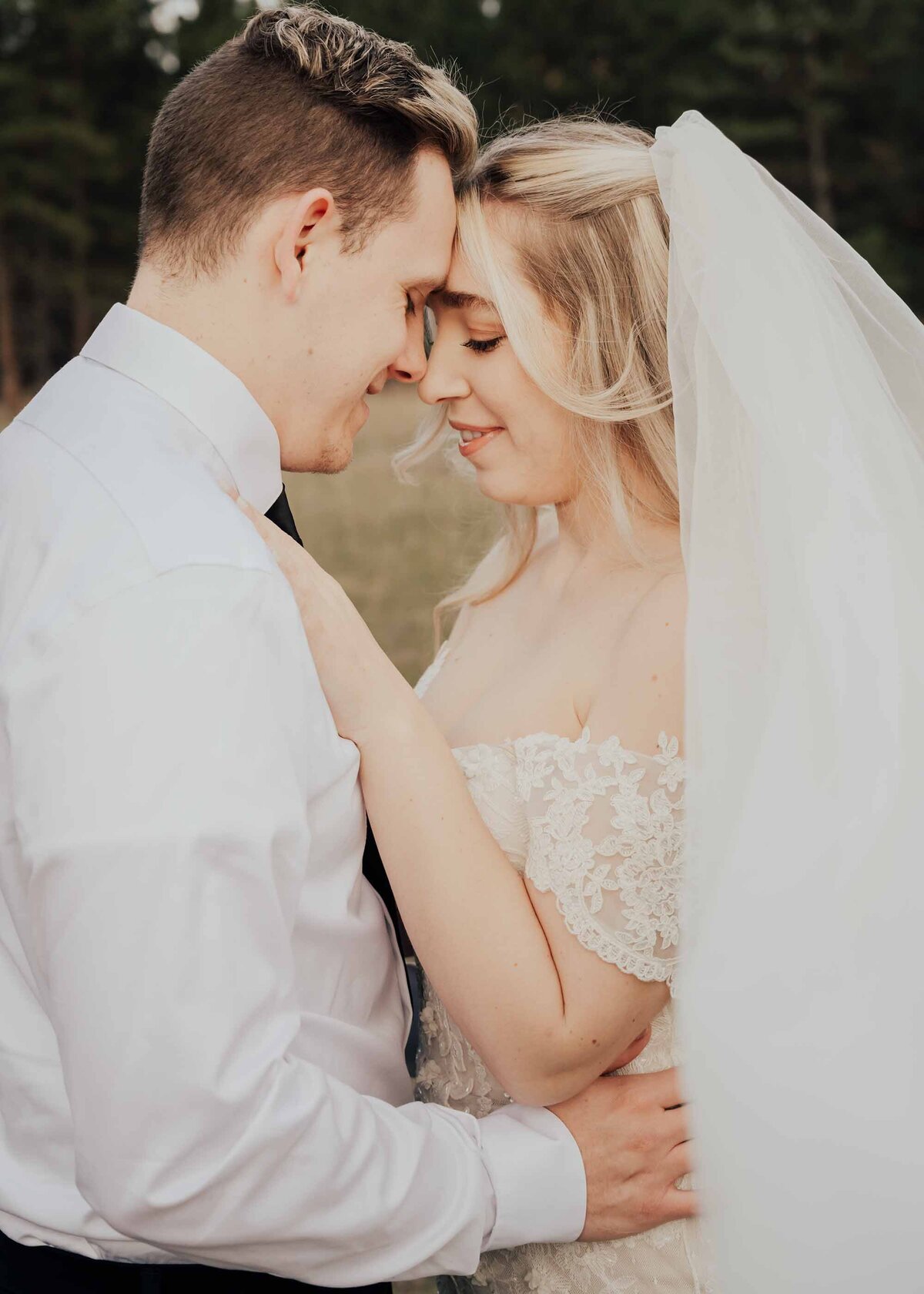 Maddie Rae Photography wedding couple standing face to face touching foreheads. her hands are on his chest and his hands are around her waist
