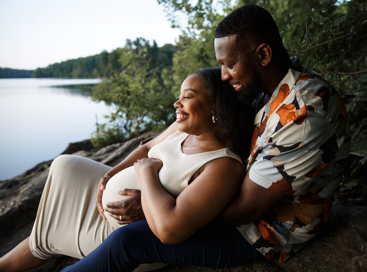 A Baltimore couple laughs during their maternity photoshoot in Baltimore County, MD