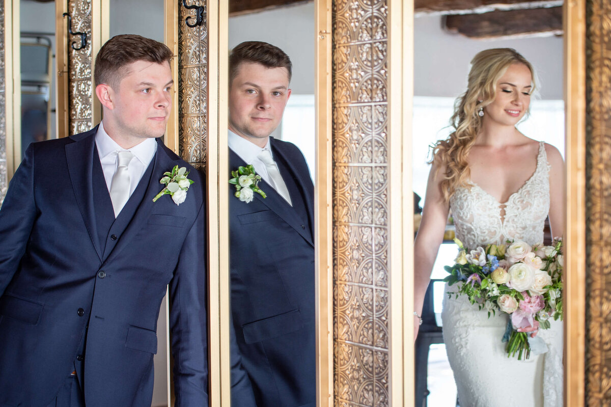 a creative photo of a bride and groom using the mirrors inside the Badchild Pub at Stonefields Estate wedding venue