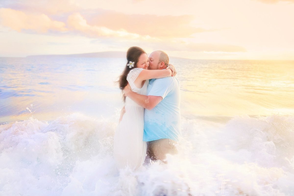 Love + Water Photography capture a Maui beach engagement with woman wearing a white dress and man wearing a blue collared shirt.