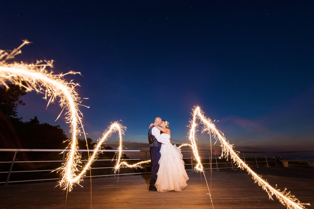 sparklers night shot of bride and groom on the boardwalk at Pavilion at Sunken Meadow wedding