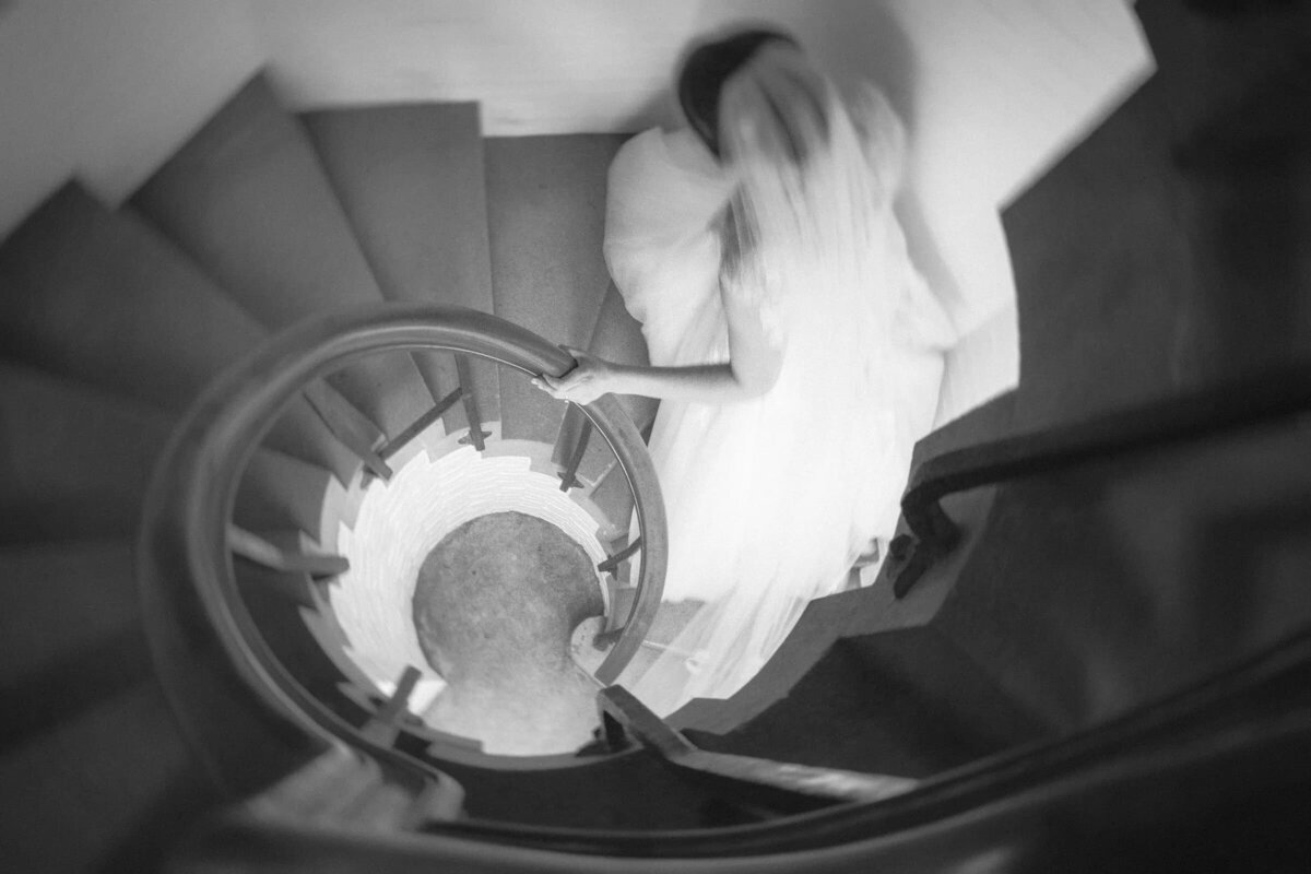 Blurred image of a bride walking up a spiral staircase