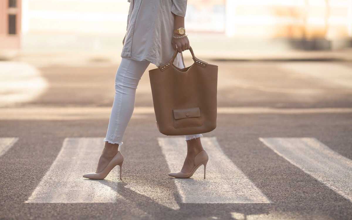 Woman wearing pumps and an oversized bag  in a crosswalk