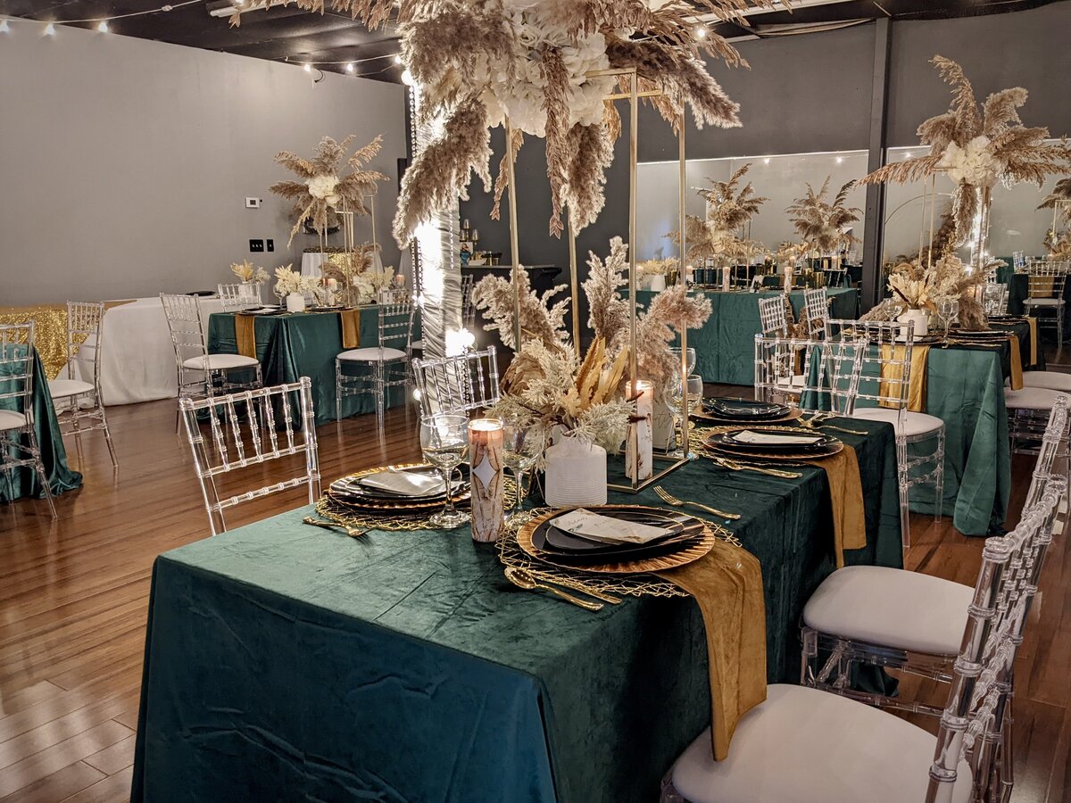 Captivating event venue with inclusive decor featuring emerald green accents and boho chivari chairs in Clearwater - Creating an enchanting and stylish atmosphere
