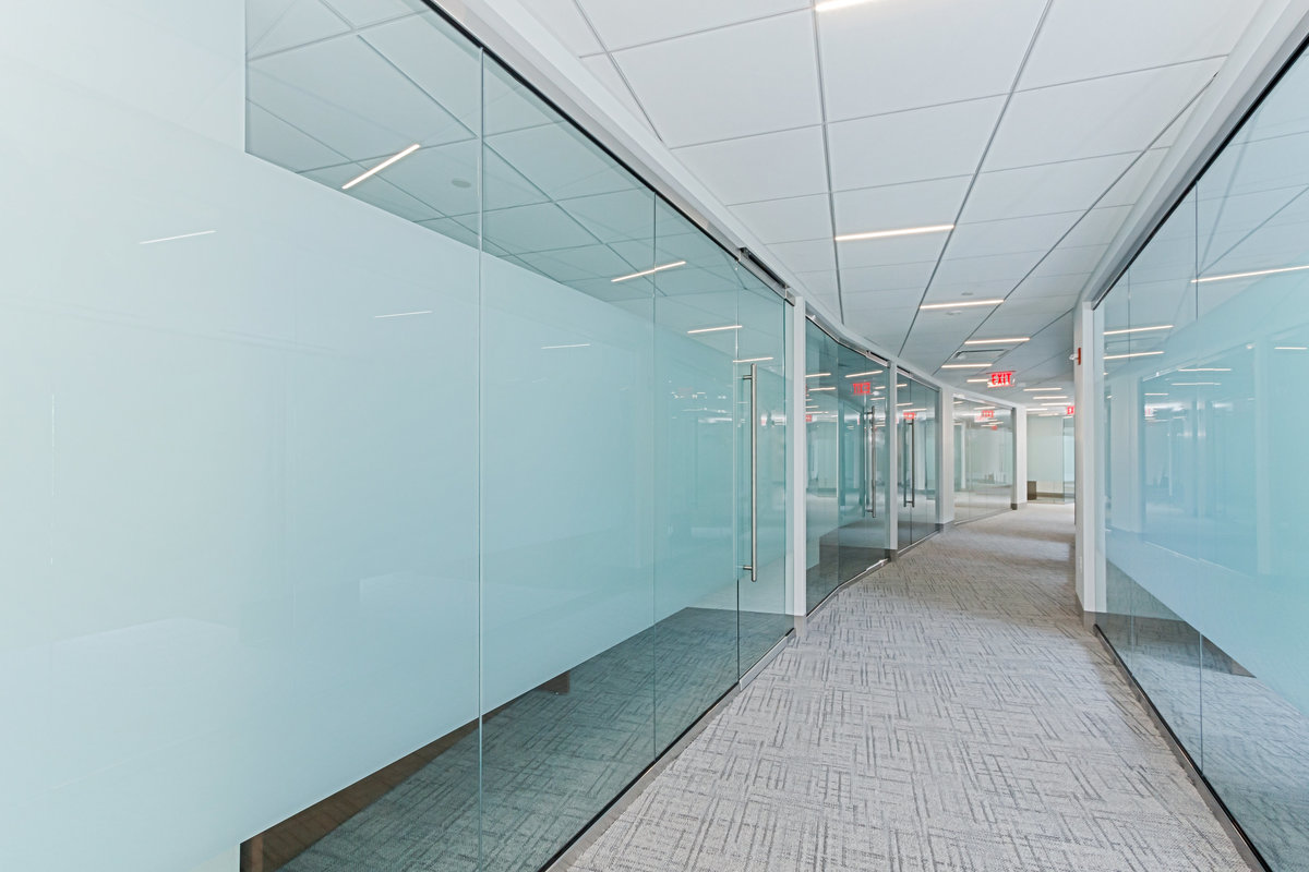 Hallway lined with glass doors leading to conference rooms.