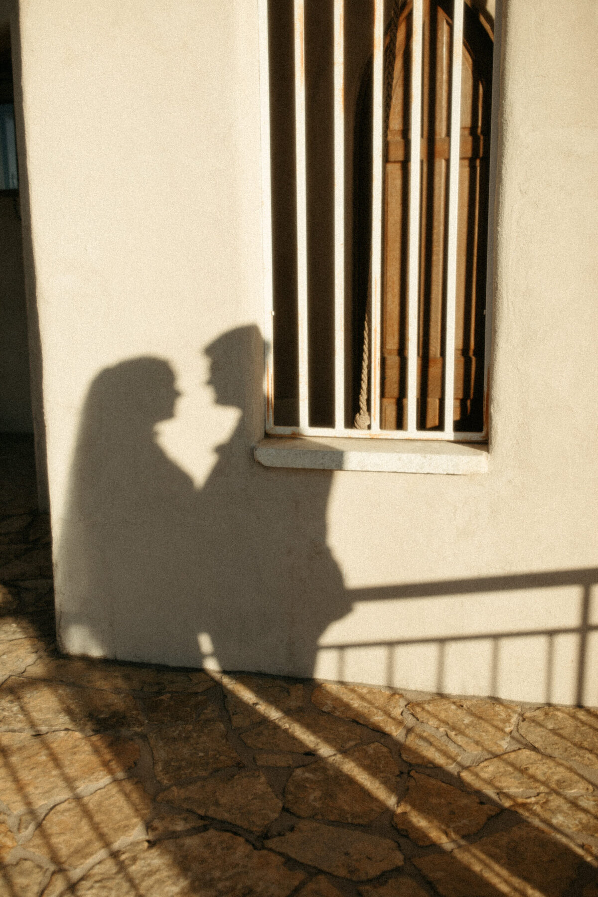 Shadow of a bride and groom on the wall of the bell tower at Chapel Dulcinea