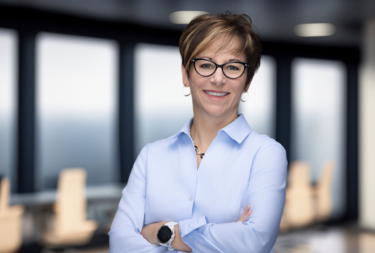 Professional headshot for personal branding in Cincinnati, featuring a Caucasian woman wearing glasses and a light blue shirt. Ideal for corporate profiles, LinkedIn updates, and business marketing materials. Highlighting the importance of high-quality, updated headshots for personal branding and professional growth. Enhance your online presence with expert headshot photography.
