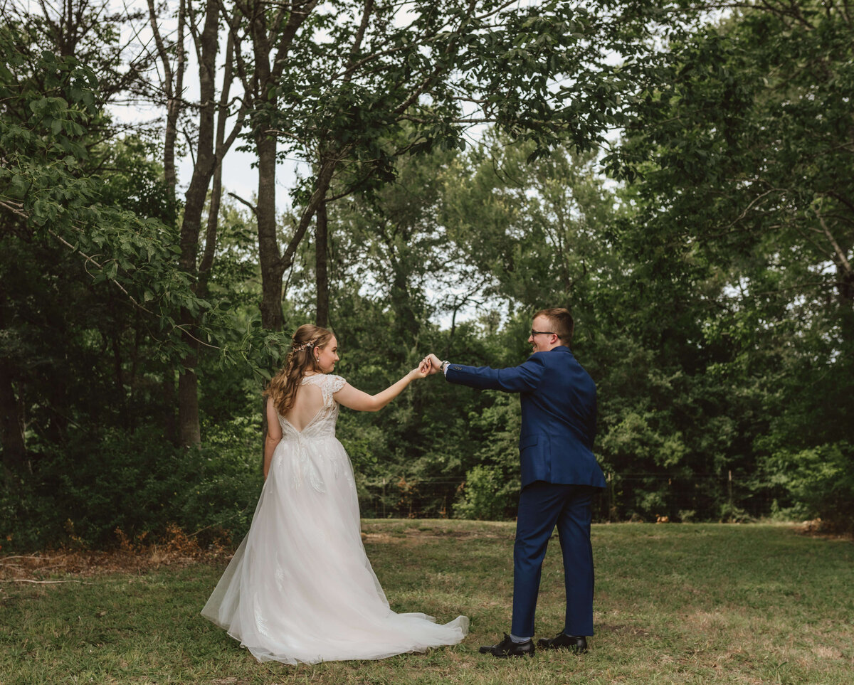 groom spins bride outside in field privately after exchanging vows
