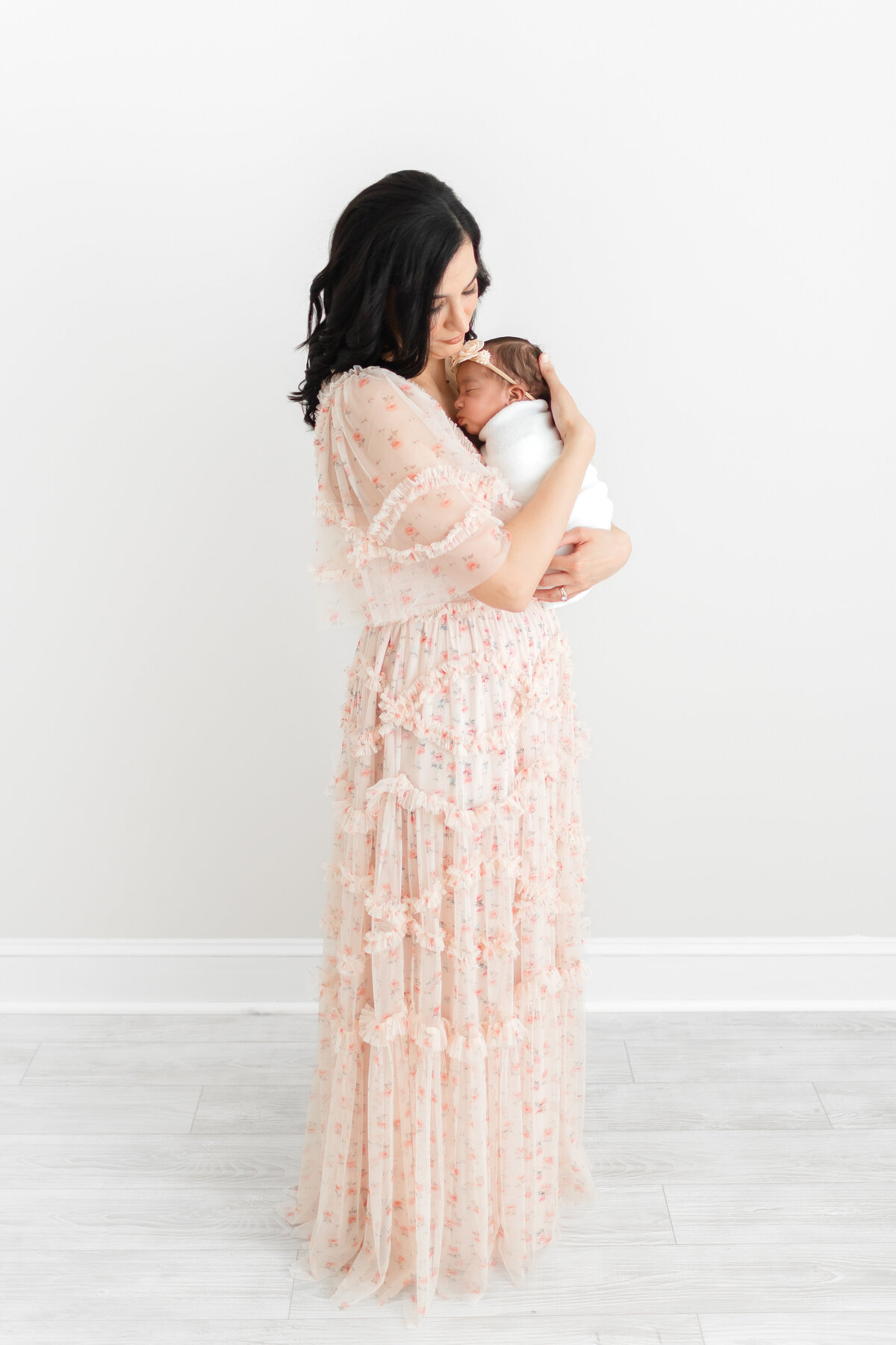 A photo of a mother snuggling her baby girl at her DC Newborn Photography photo session