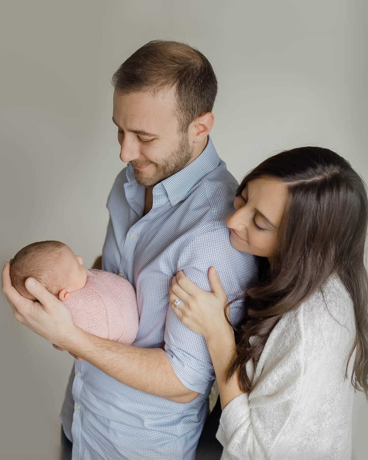 mom and dad holding newborn girl