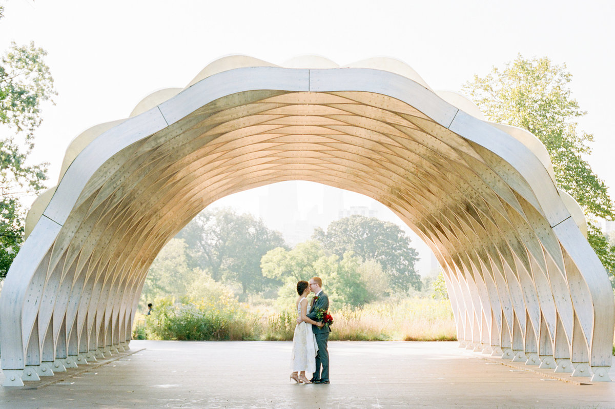 couple dancing under arch on sunny day