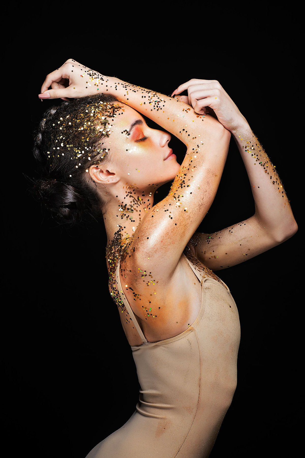 dancer covered in gold glitter in pose
