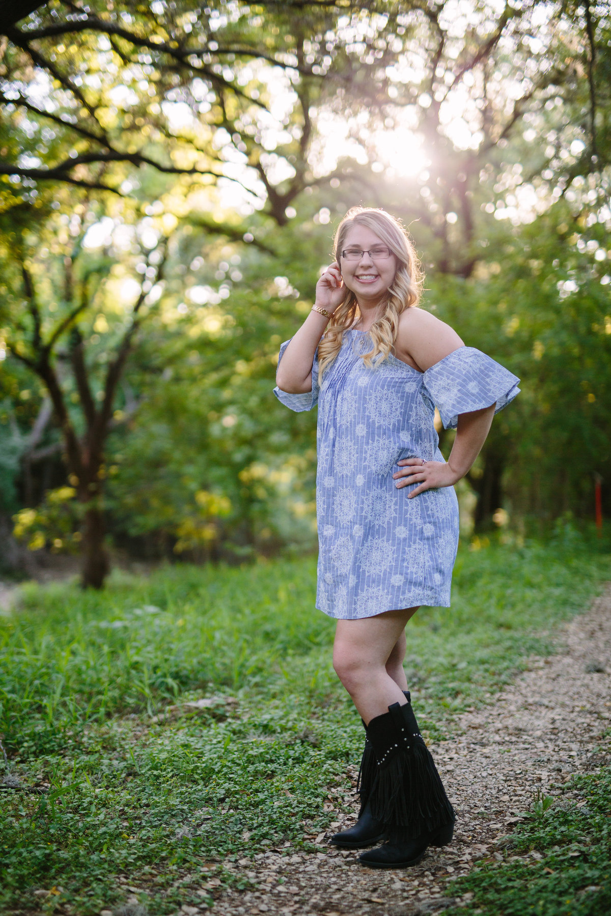 high school girl posing wearing boots for session by San Antonio high school senior photographer