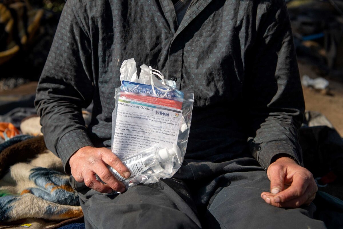 Sanitation Pack handout in hand of homeless man