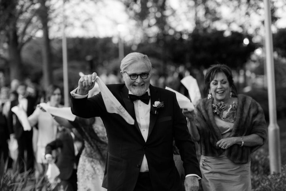 Father-of-bride-waving-flag-during-second-line-City-Park-sculpture-garden-wedding-New-Orleans.jpg
