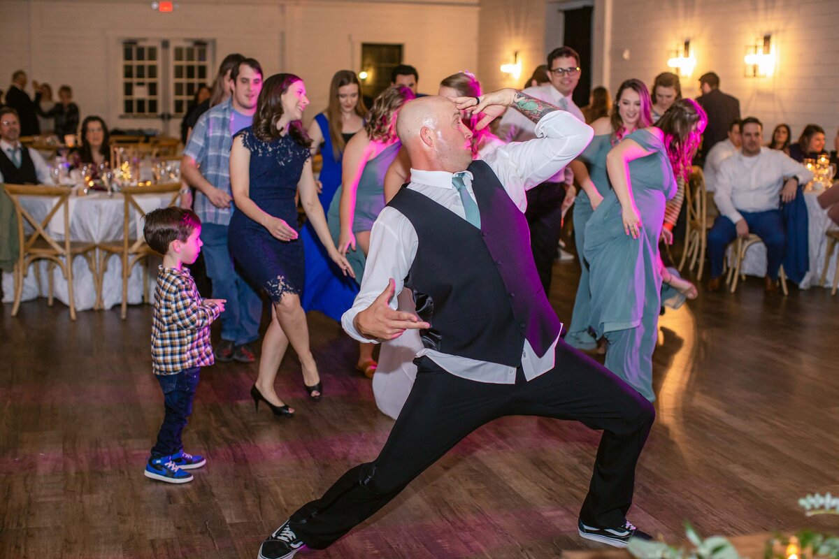 Fort Worth wedding photographer captures dancing at reception with purple stage light