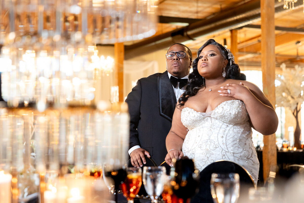 A couple celebrates at their elegant wedding reception under sparkling crystal chandeliers in a luxurious venue at Bibb Mill Event Center