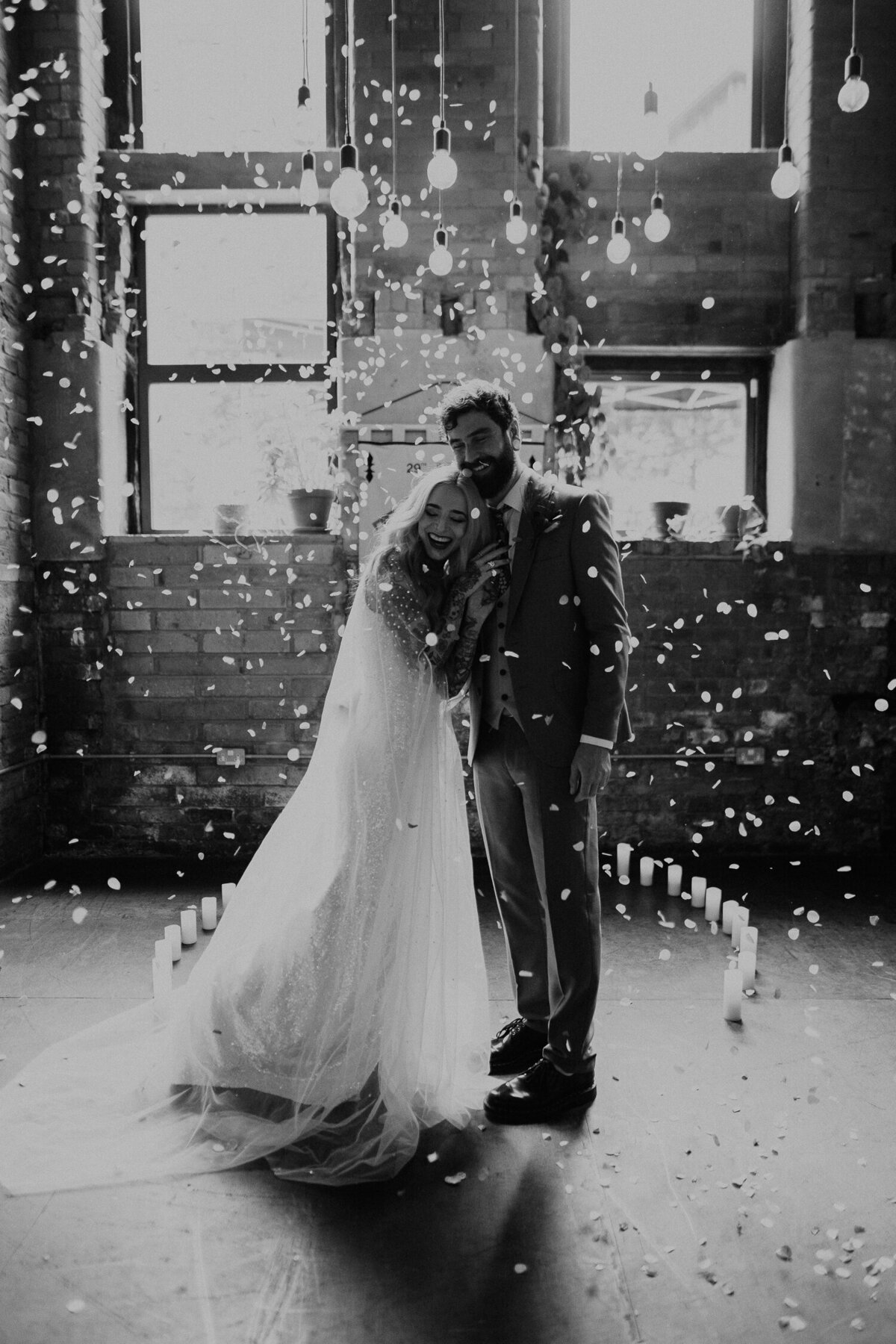 An alternative wedding couple are covered in confetti at their wedding in Manchester.