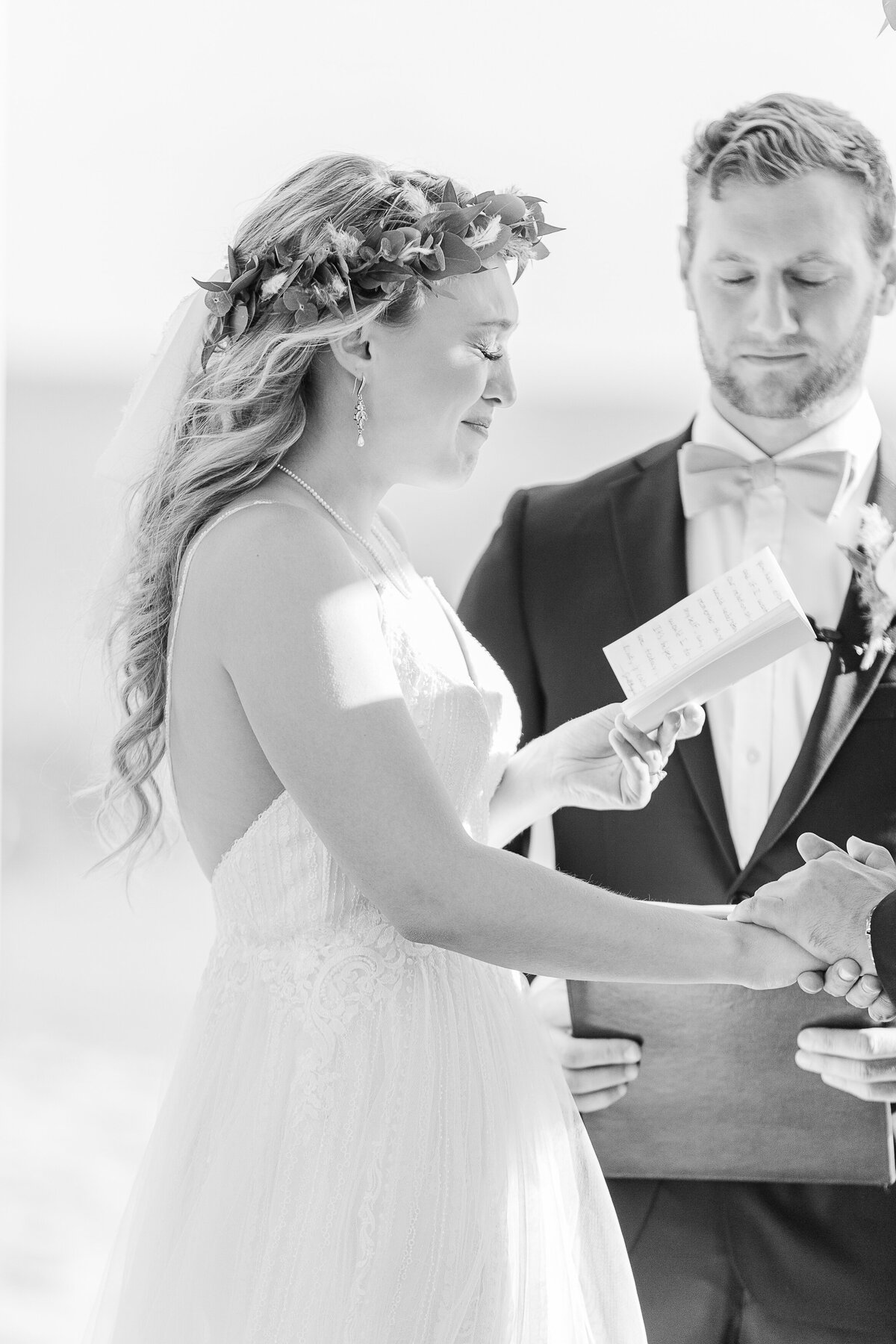 Bride tearfully reads her vows at her Madison Beach Hotel wedding ceremony. Captured by best New England wedding photographer Lia Rose Weddings.