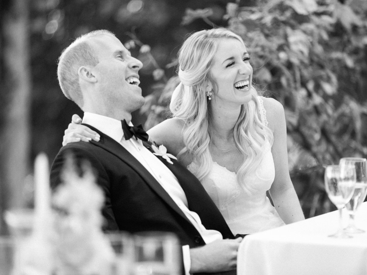 bride and groom laughing during wedding toasts