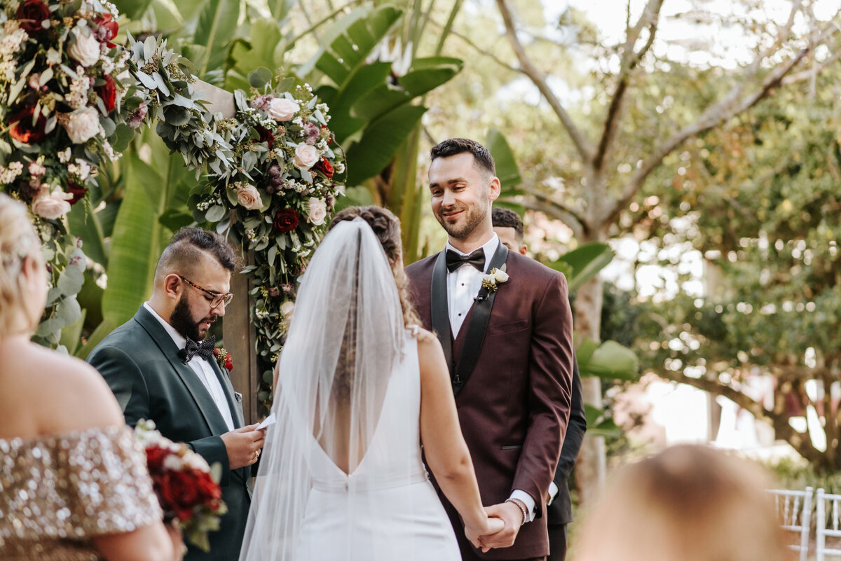 alt="bride and groom holding hands garden wedding"
