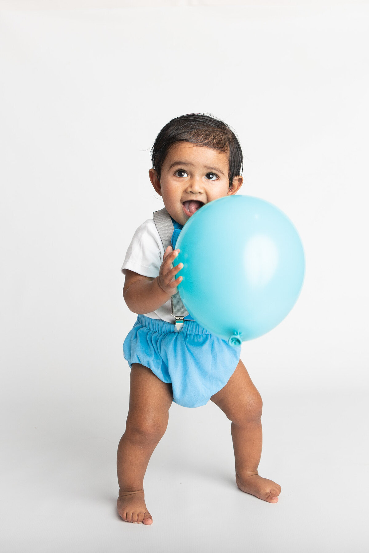 Baby holding a blue balloon
