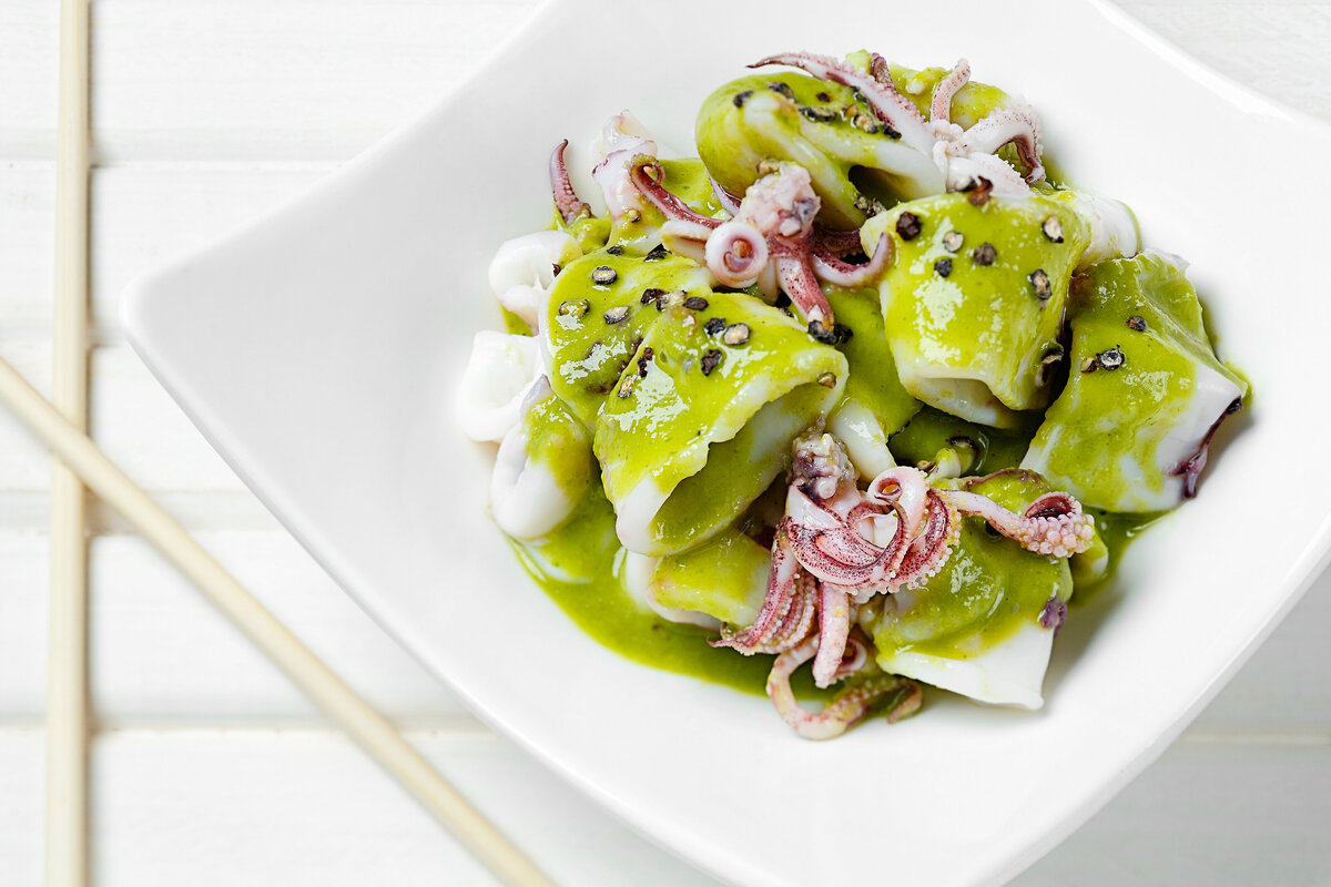 A seafood dish covered in green sauce