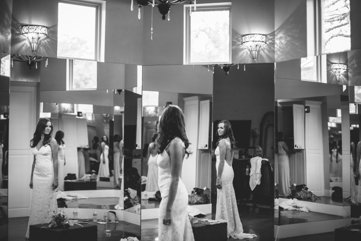 Bride looking at herself in mirror prior to wedding ceremony as she gets ready at Remi's Ridge at Hidden Falls