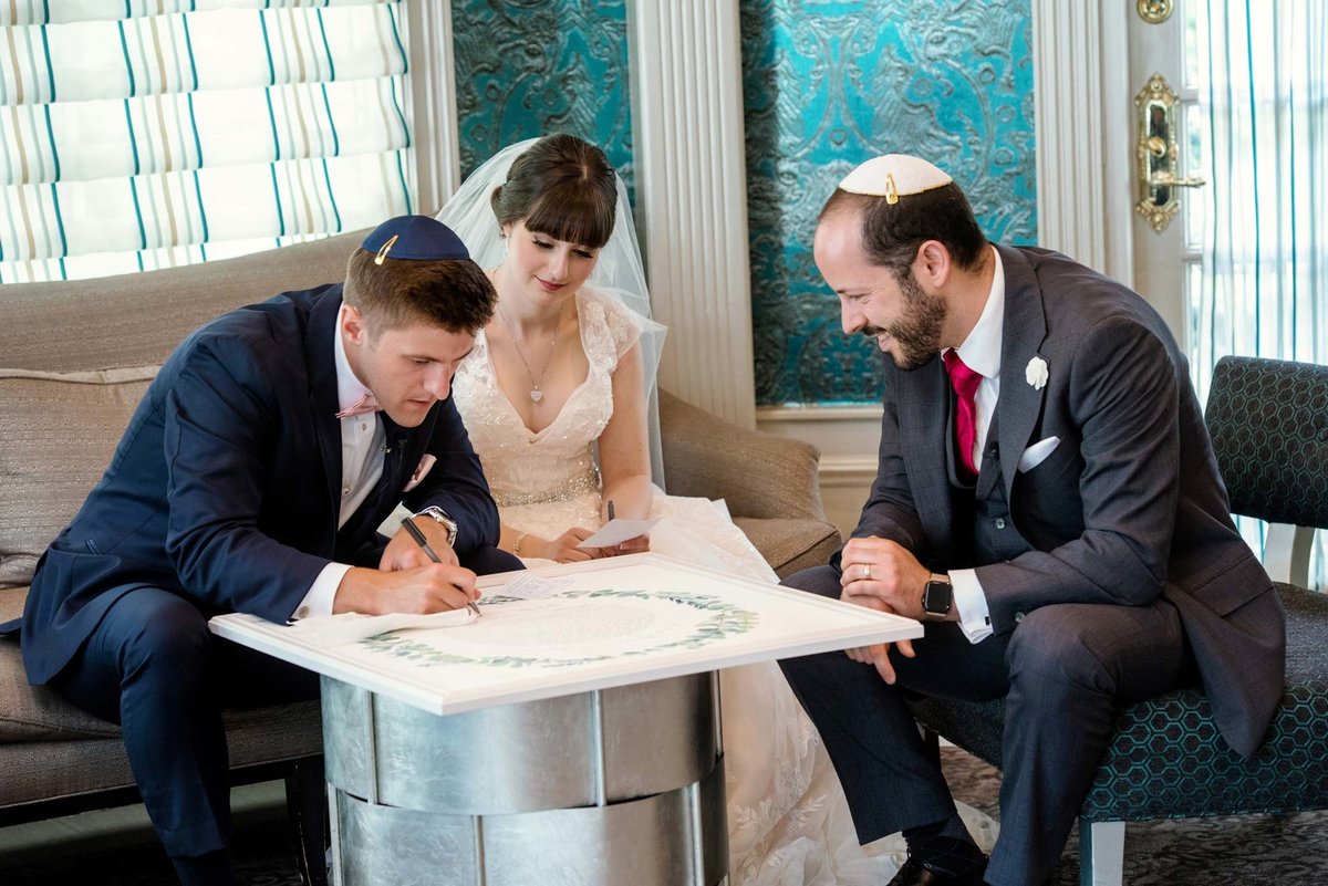 Fox Hollow Jewish wedding ceremony, bride and groom signing the ketubah