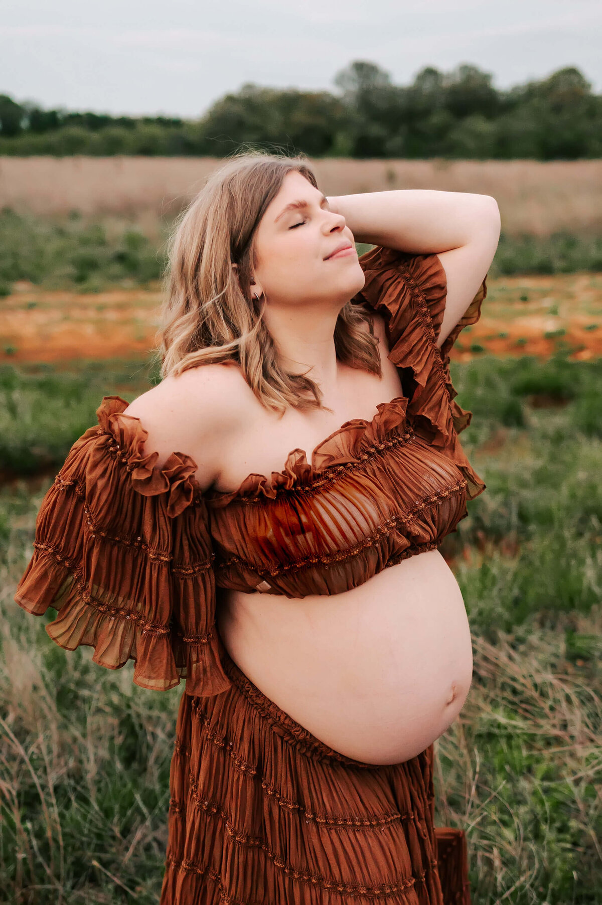 maternity photo in Springfield MO of pregnant mom closing her eyes in a field