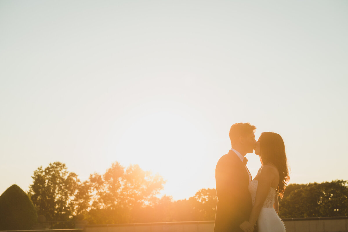 bride and groom kissing at sundown at Oheka Castle
