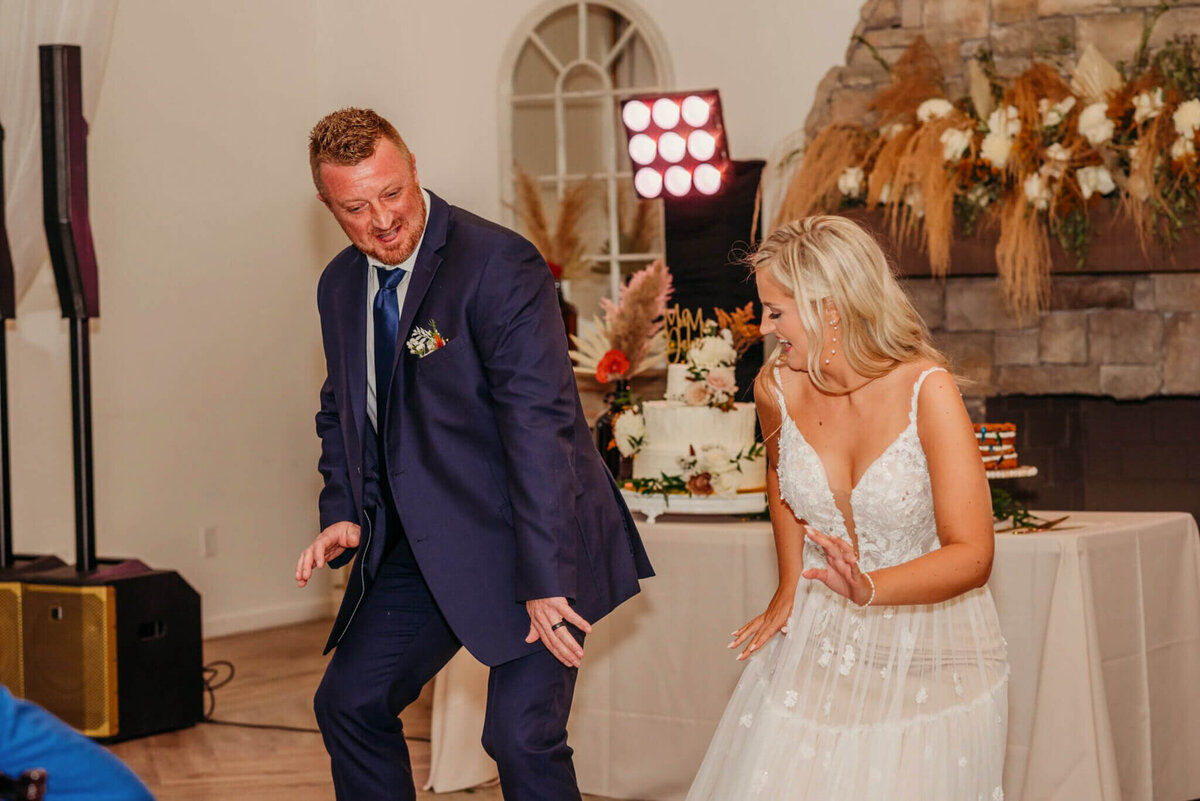 Photo of a bride and her dad dancing side-by-side to fun music