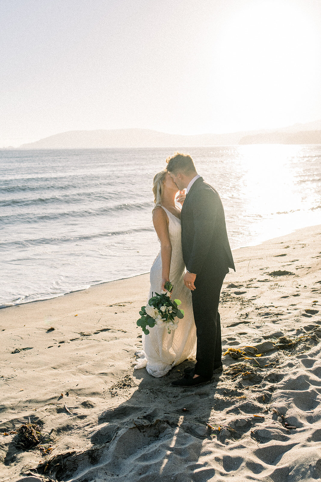 Bride and groom the beach at sunset at Dolphin Bay Resort in Pismo Beach, CA