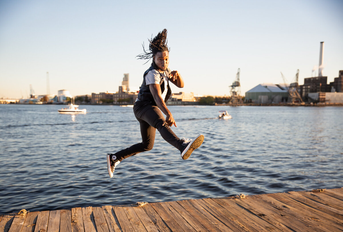 An-entrepreneur-jumps-near-inner-harbor-water-during-a-fun-branding-photoshoot-with-Ingrid-Berrios-Photography-in-Baltimore-Maryland