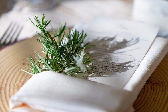 a bunch of herbs tucked into ivory napkin