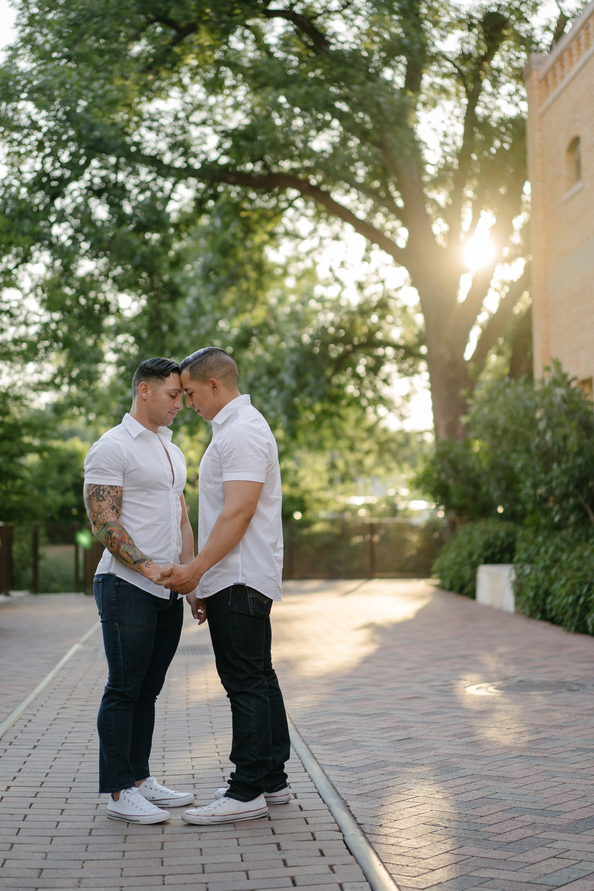 Engaged same sex couple. Two soon to be married men touching heads and holding hands at the Historic Pearl in downtown San Antonio.